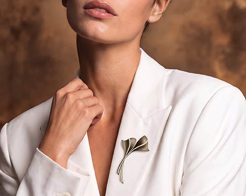 Modella indossa una spilla Ginkgo da donna con diamanti su giacca bianca, collezione Like Me Giorgio Visconti