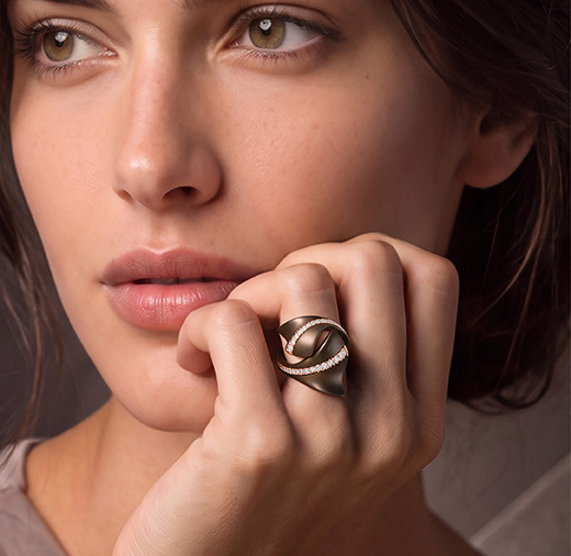Modella indossa anello Ginkgo da donna in titanio chocolate, oro con diamanti della collezione Like Me Giorgio Visconti