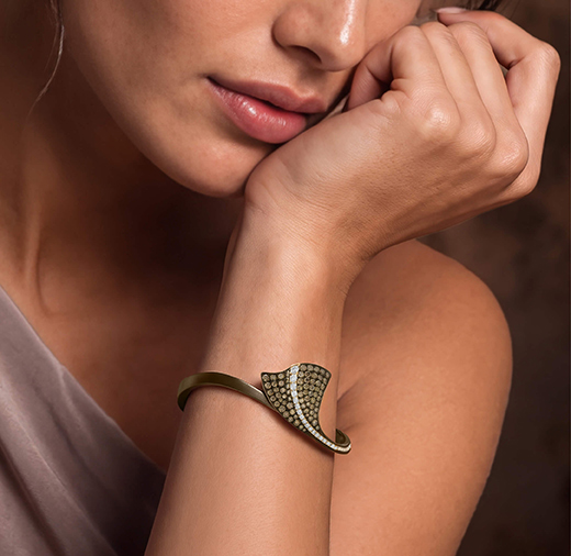 Dettaglio di bracciale Ginkgo da donna in titanio chocolate, oro e diamanti indossato al polso – Giorgio Visconti